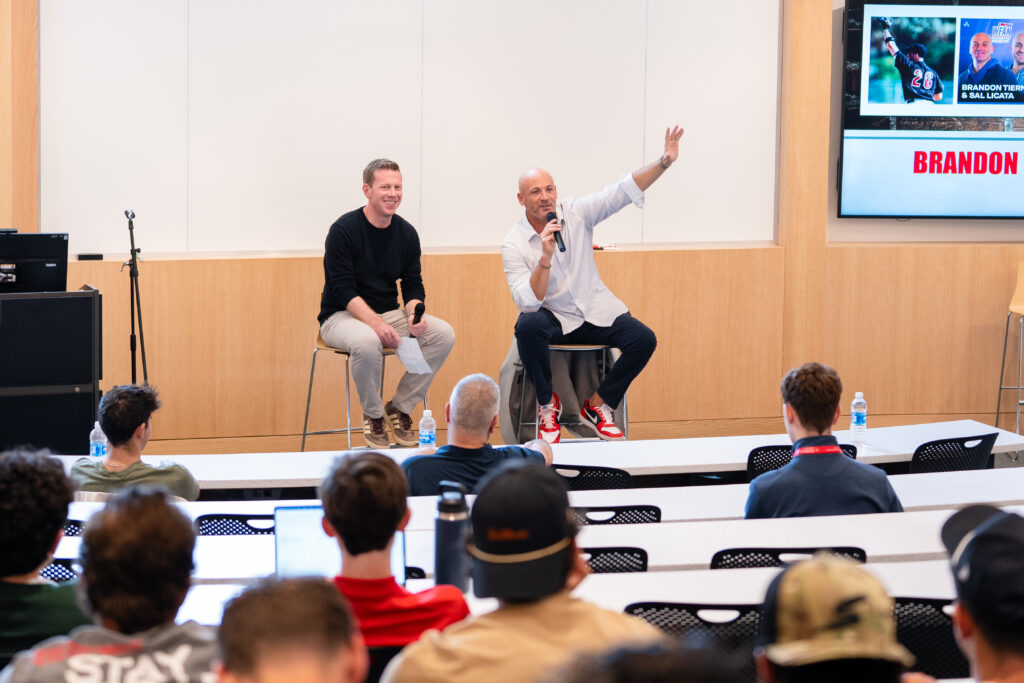 Two men speaking to an audience in a casual setting.