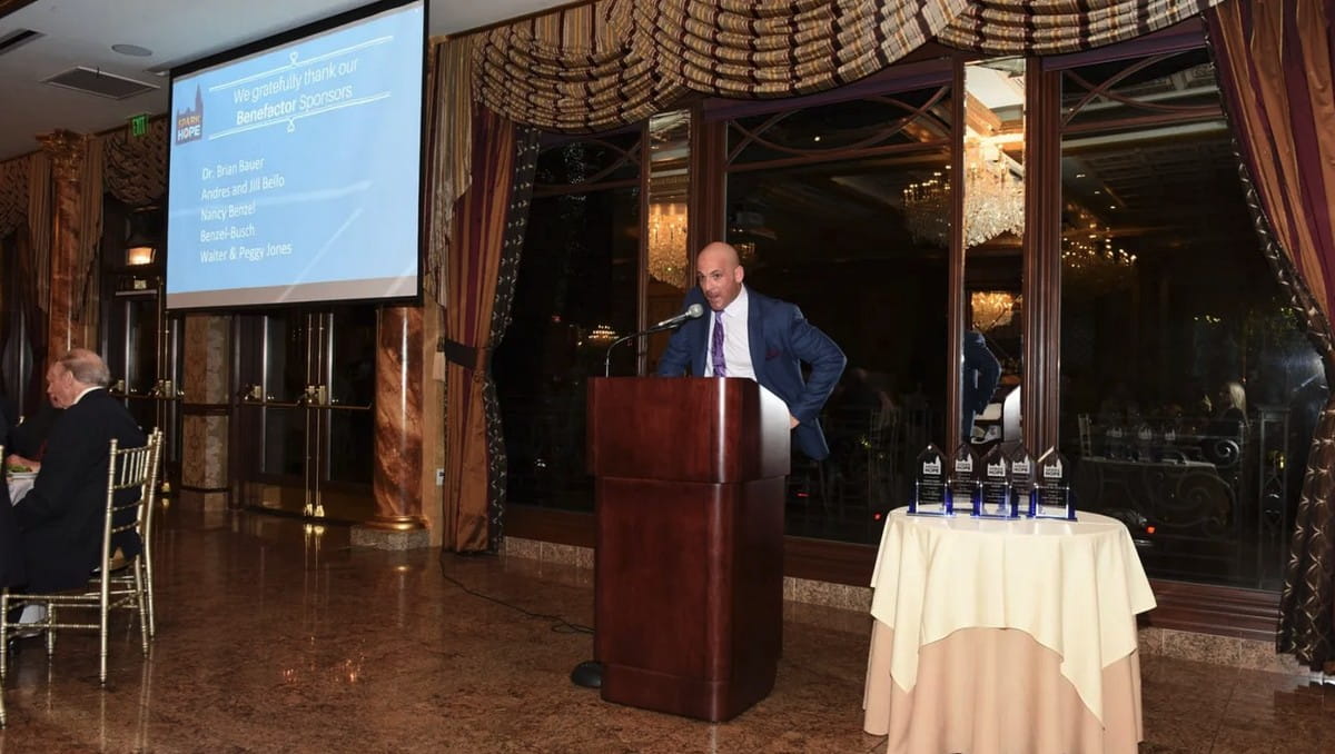 Man speaking at podium during event.