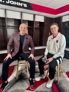 Two men sitting in a locker room.