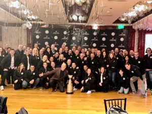 Group celebrating with a trophy indoors.